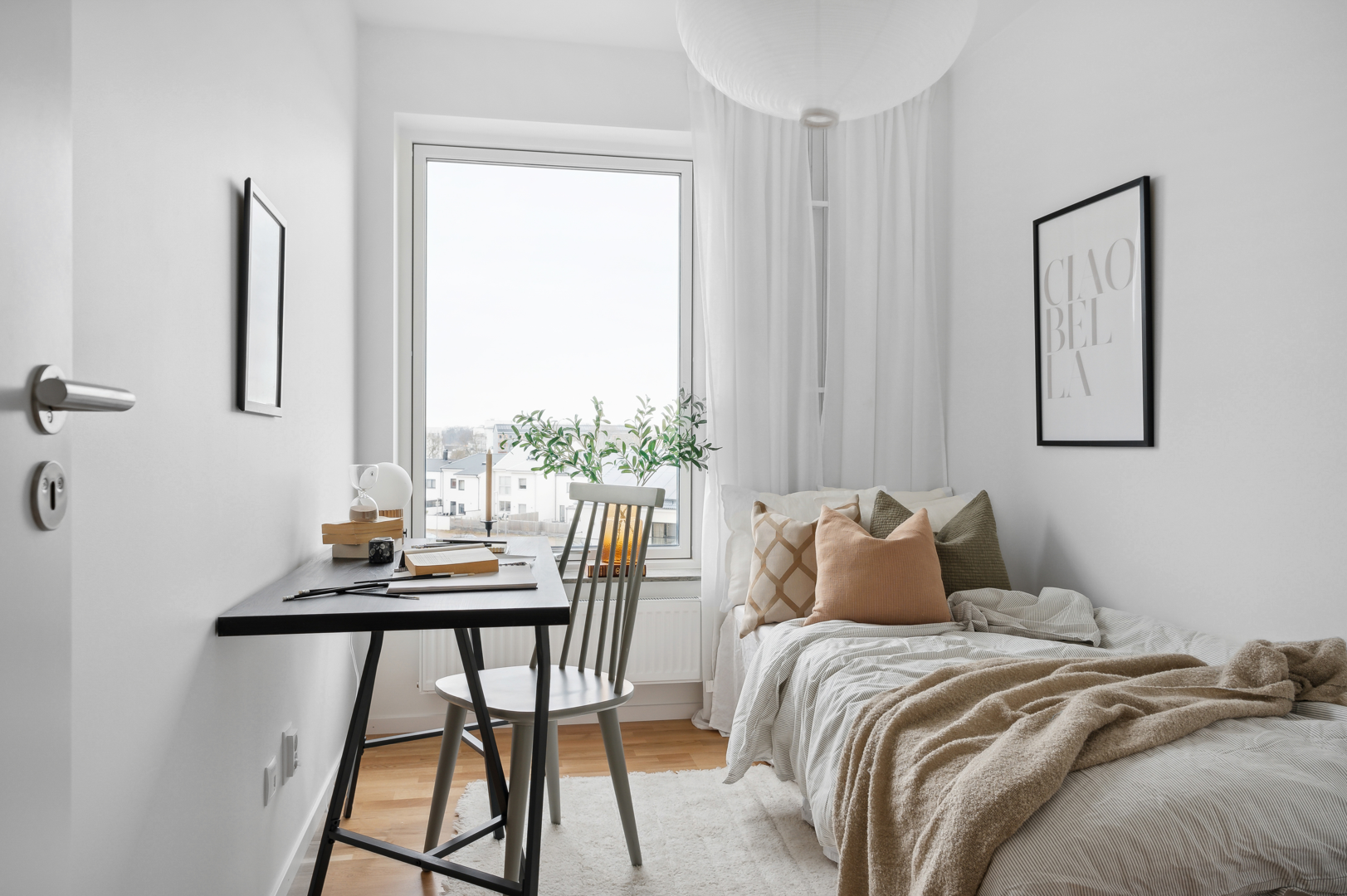 Skrivbord och säng i lägenhet i Landskrona