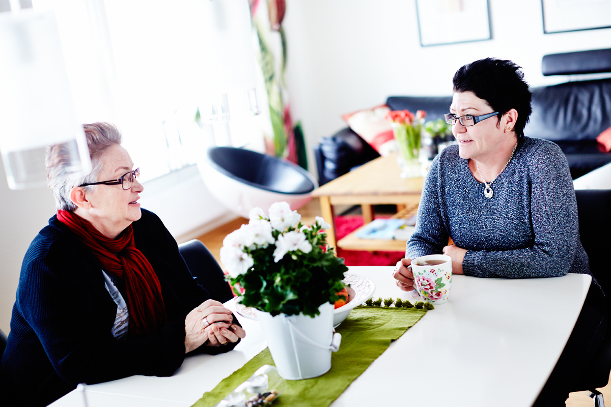 Två personer diskuterar brandsäkerhet och ventilation runt ett bord