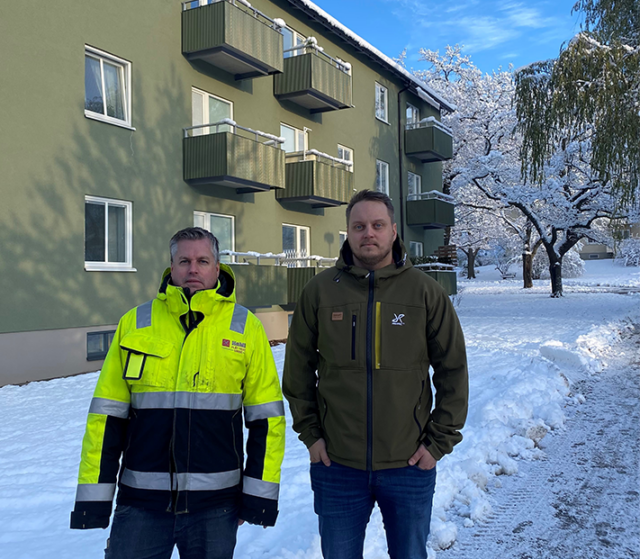 Två byggansvariga utanför byggnad