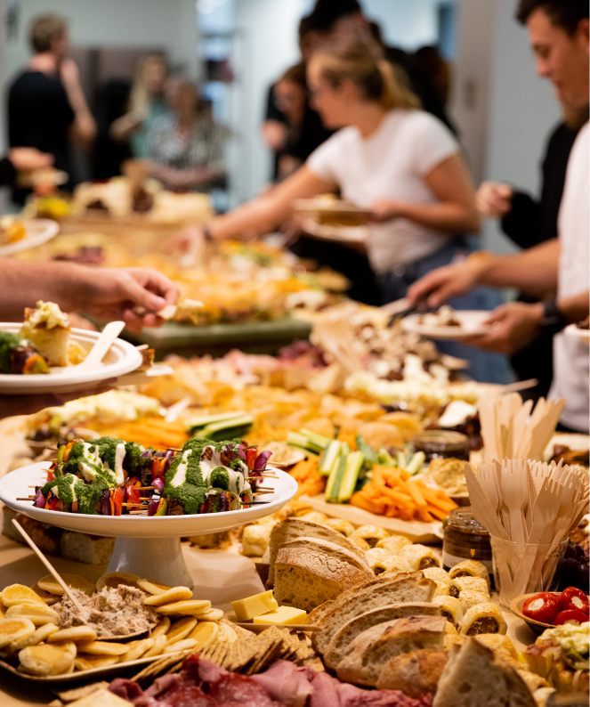 Grande assiette de charcuterie, membres de l'équipe flous à l'arrière-plan