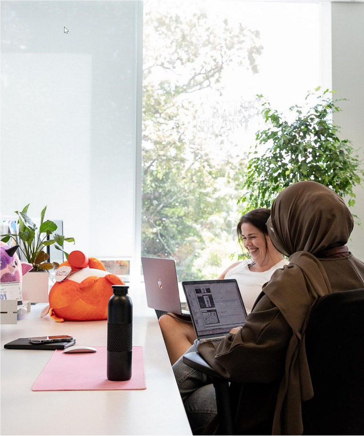 Deux collègues de travail assis à un bureau avec des ordinateurs portables
